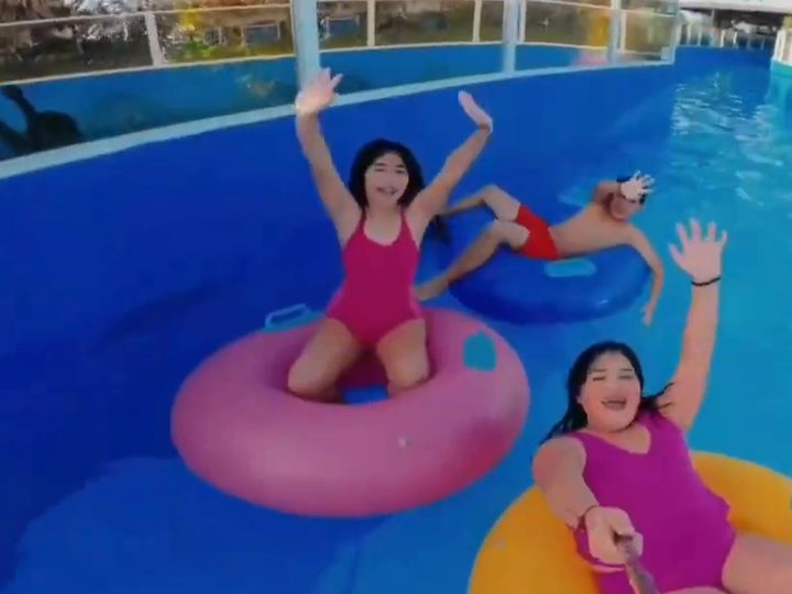 Personas en flotadores en la piscina con olas